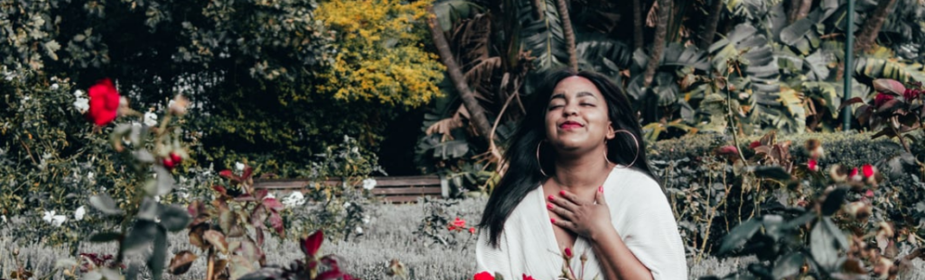 mujer en un jardin mostrandose agradecida