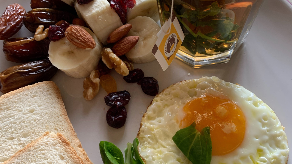 desayuno con huevo frito, frutos secos, pan y te